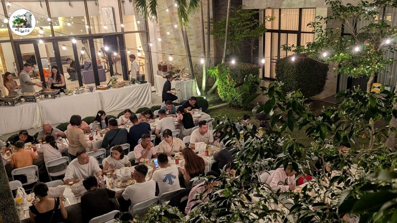 嘉義泰勒瓦莊園戶外婚禮宴會實景，夜色下的燈串與長桌用餐區，賓客自在取餐與交談的溫馨氛圍
